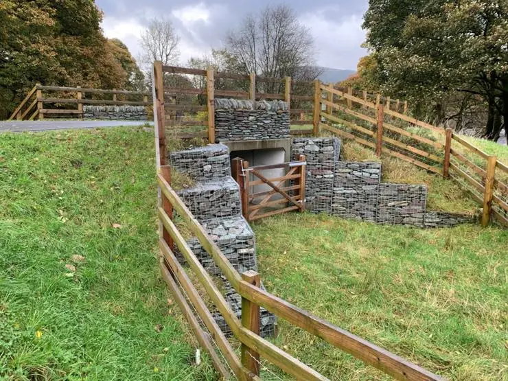 A livestock field access created underneath the Keswick to Threlkeld trail by using a concrete box tunnel with supporting reinforcement provided by gabions.