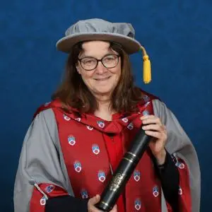 Honorary Doctorate Professor Helen Marshall OBE holding a scroll