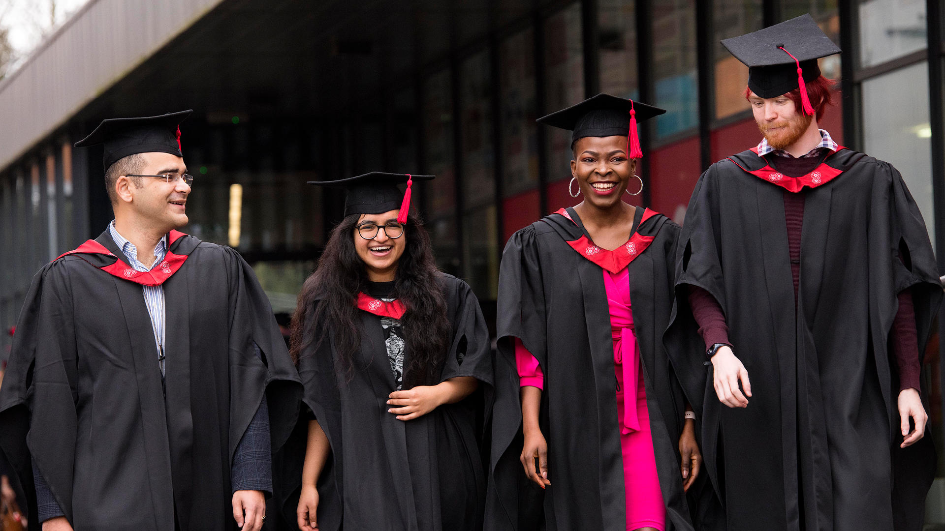 UCLan graduates in robes walking through campus