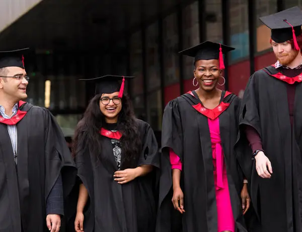 UCLan graduates in robes walking through campus