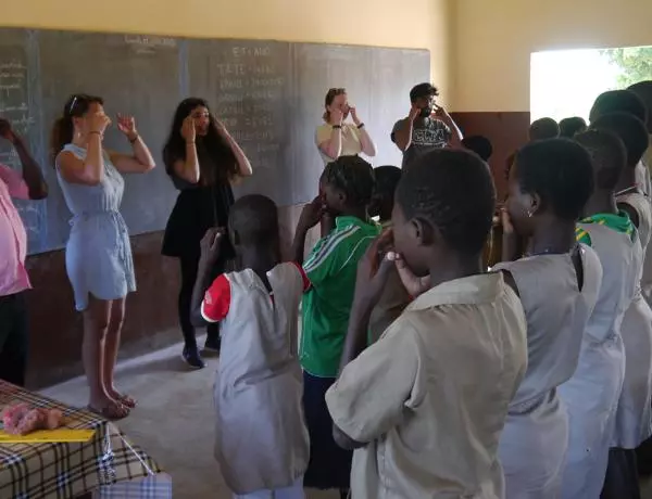 students and teachers in a classroom holding their faces