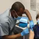 Pharmacy student Ibua Chinedu-Bidwell vaccinating a patient