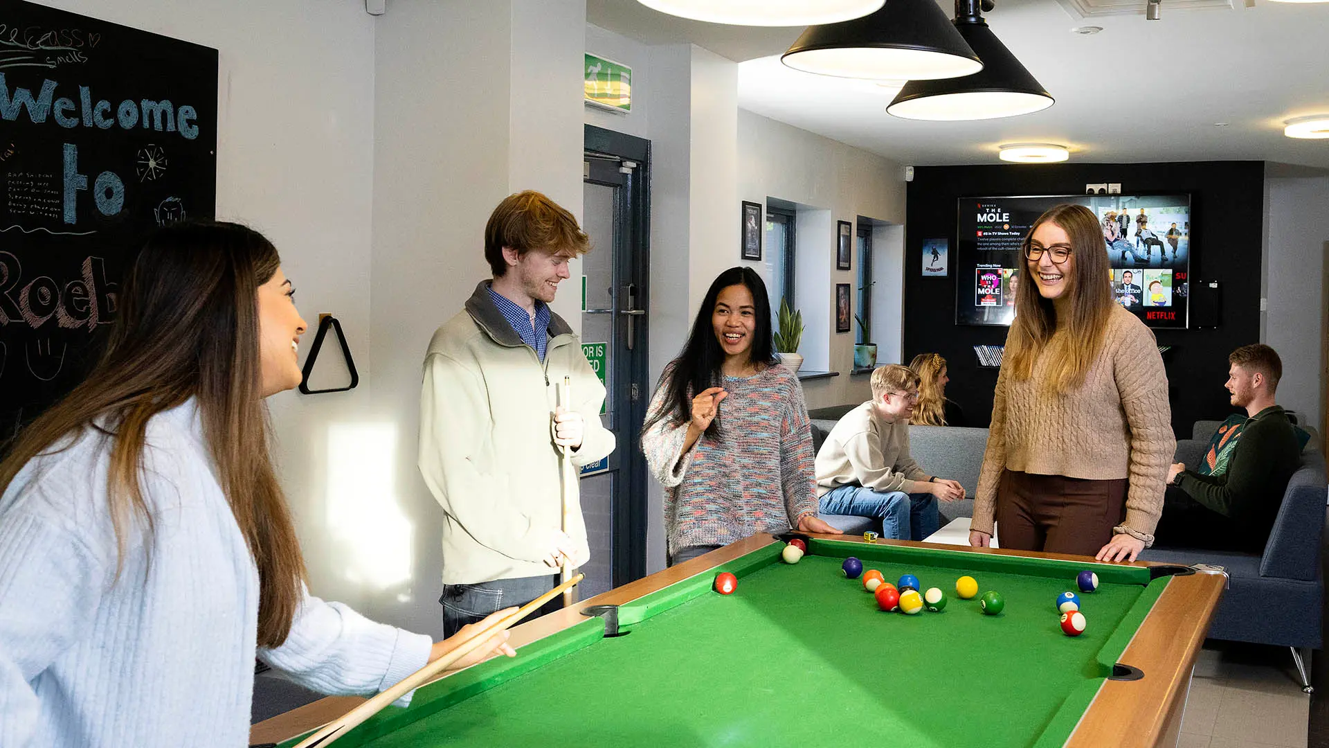 students playing pool in roeburn common room