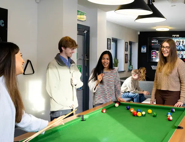 students playing pool in roeburn common room
