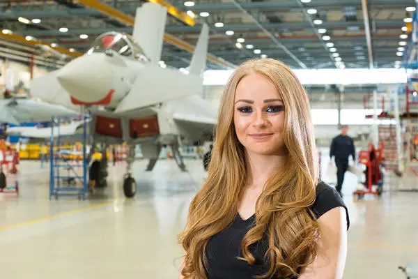 Alumni Hayley Dickinson stood by a plane in a large workshop
