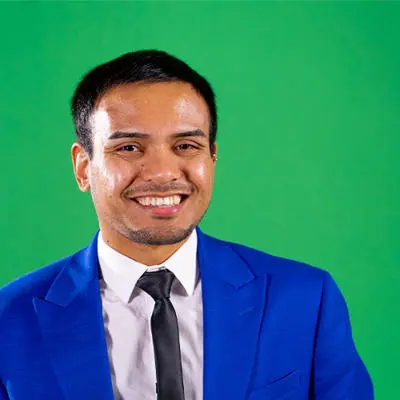 Business and Marketing student Mason Karki wearing blue suit in front of green background