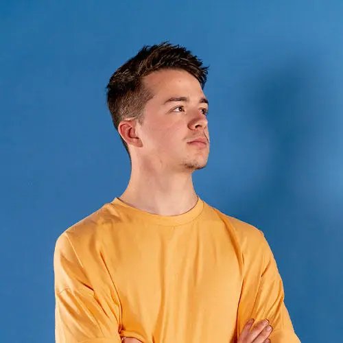 Accounting student Matt Allen wearing an orange t-shirt stood in front of a blue background