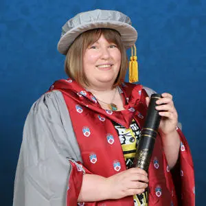 Becky Chilcott in graduation gown with Honorary Doctorate