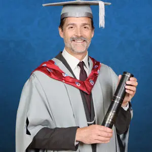 Patrick Grant in graduation gown with Honorary Fellowship