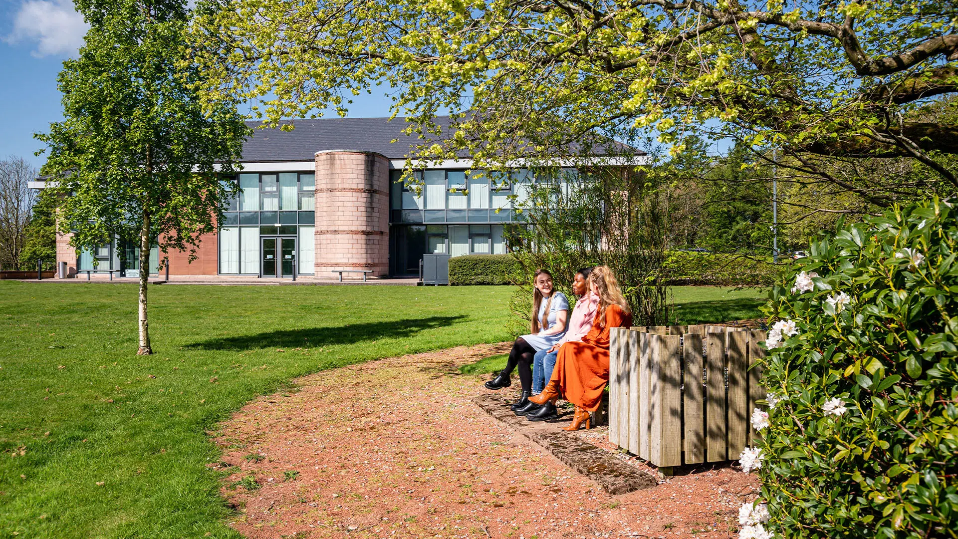 Students sat on bench enjoying green space at our Westlakes Campus