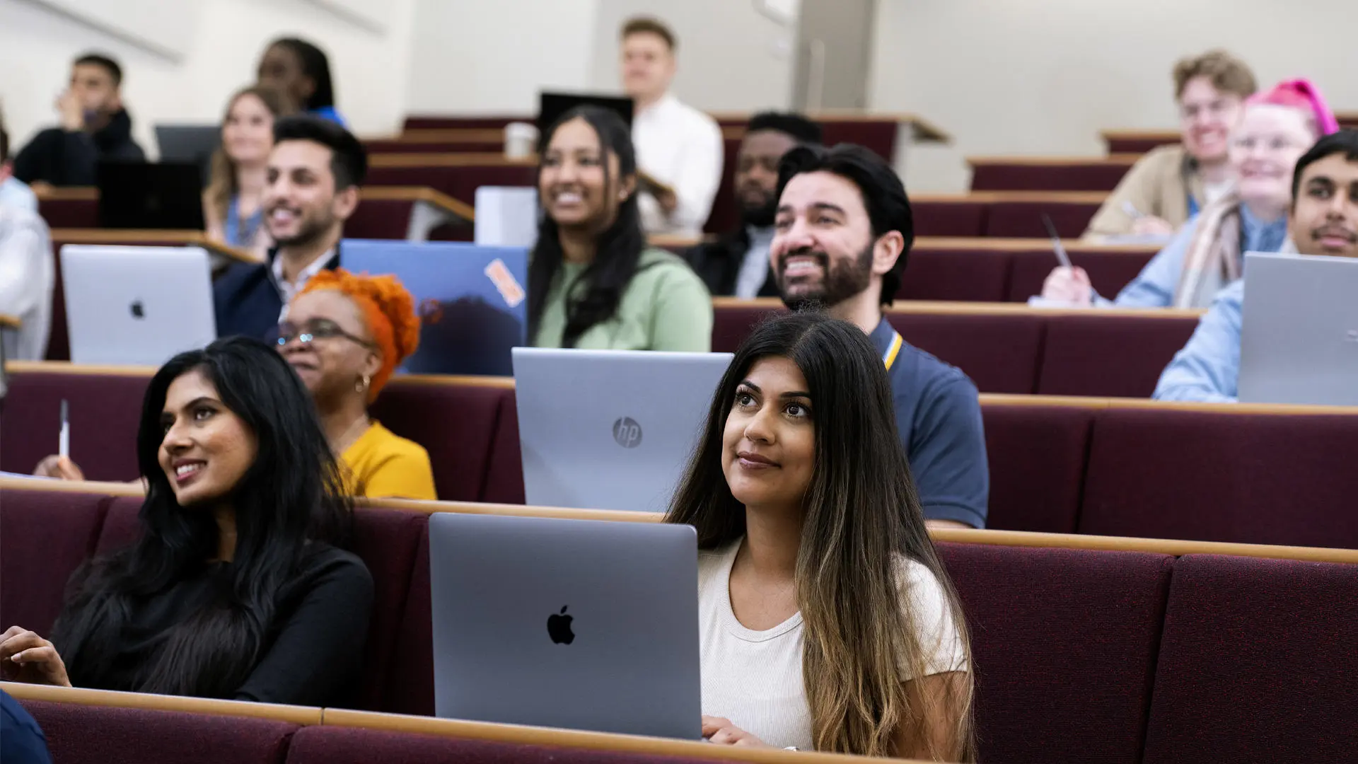 group of students sat with laptops in foster lecture theatre