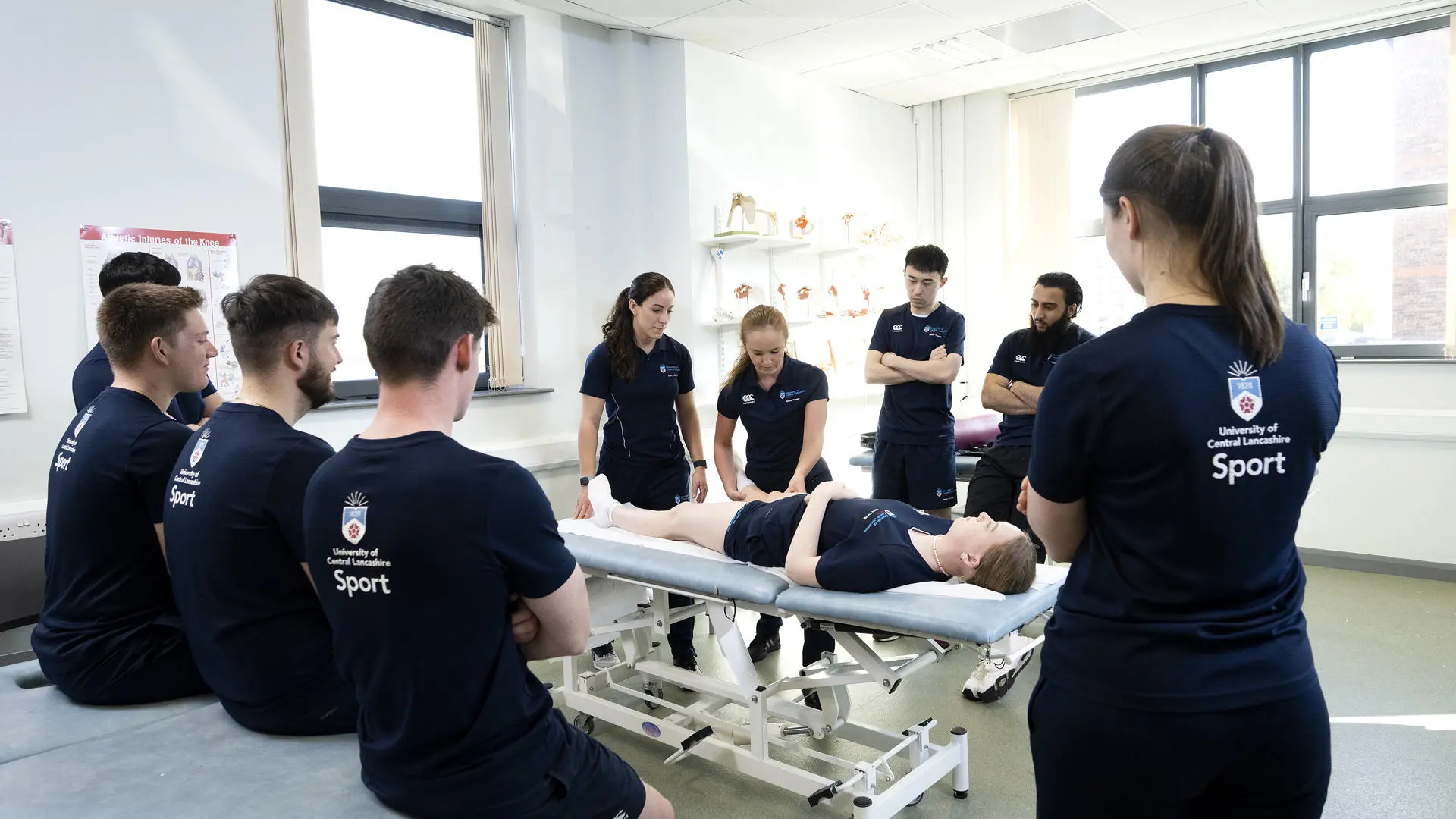 group of sports therapy students observing a patient