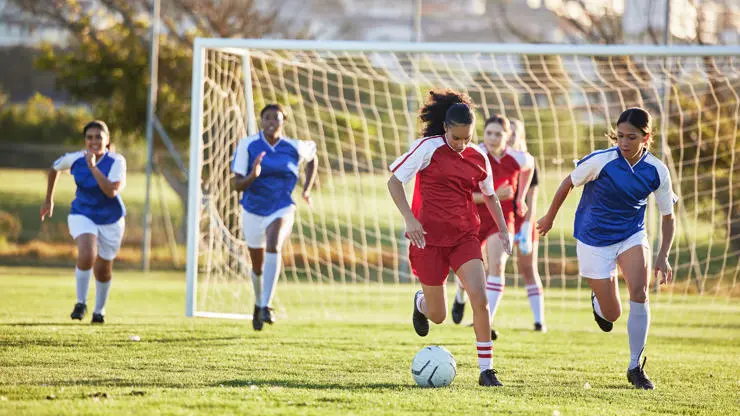 Adolescent girls playing football