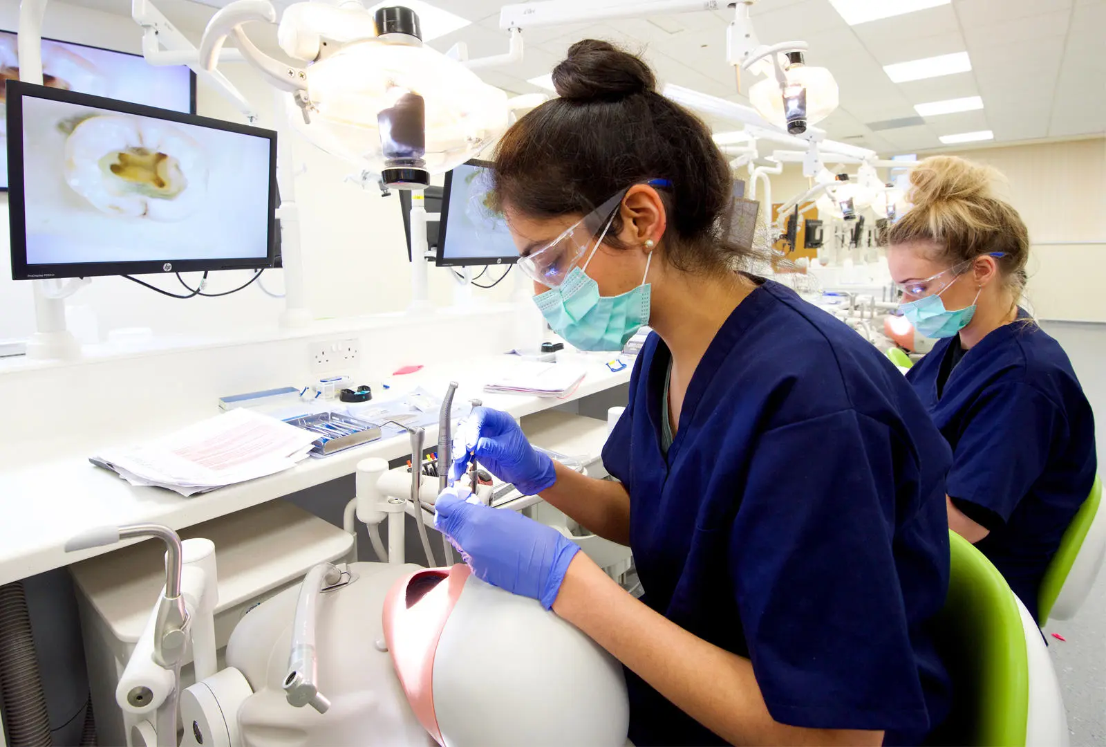 student operating on phantom head equipment in dental surgery