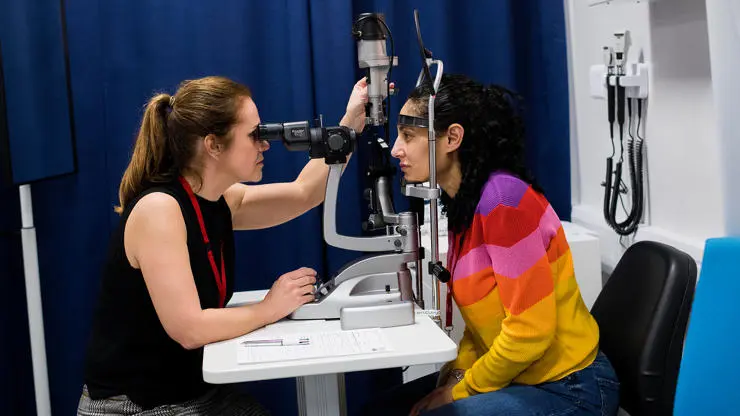 Optometry student using eye clinic equipment