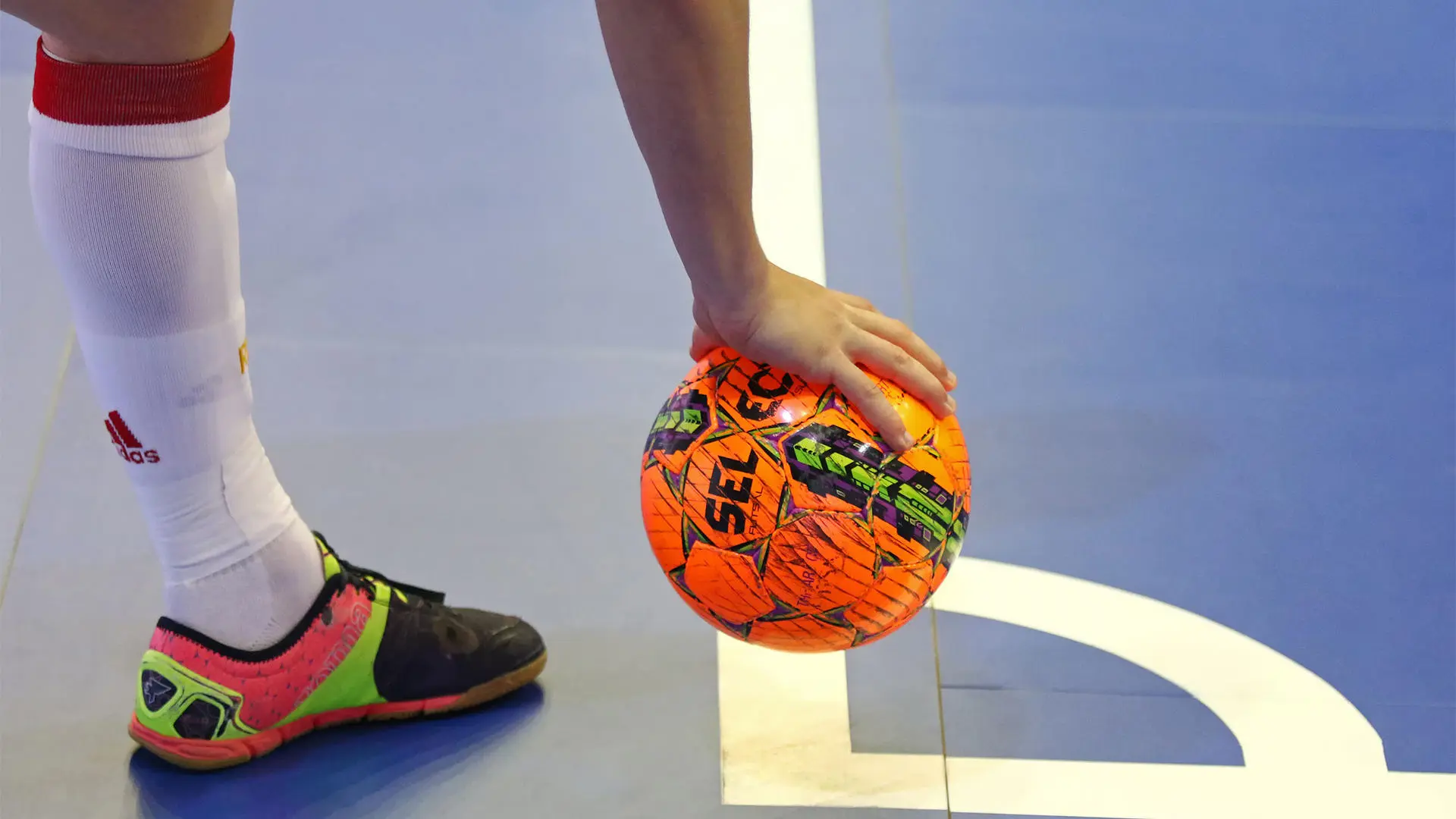 Hand placing a football on court