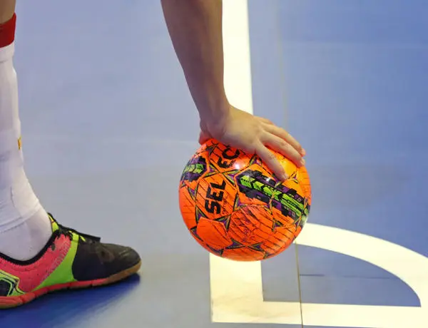 Hand placing a football on court