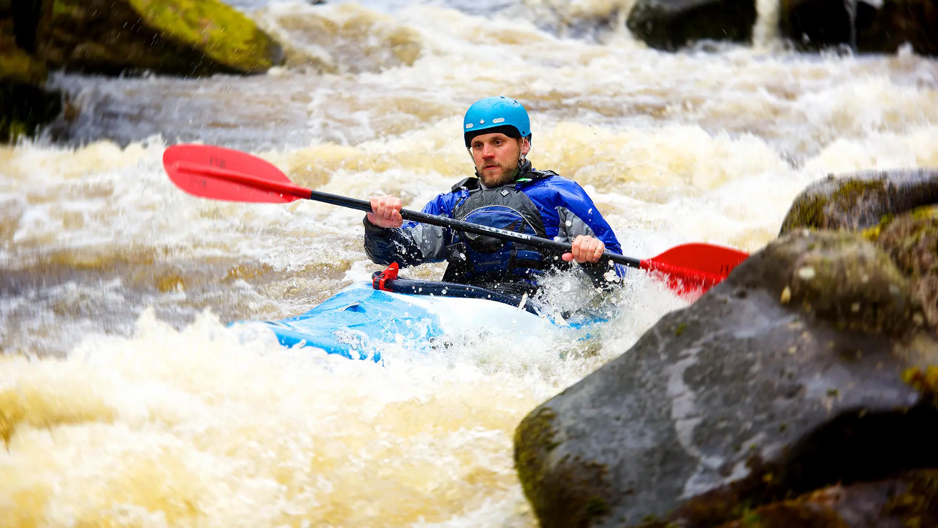 student canoeing in rapids