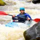 student canoeing in rapids