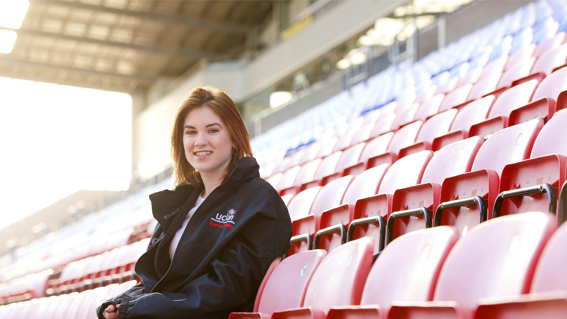 Sports student sitting in seats at a football stadium
