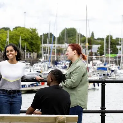 group of students stood and sat on benches in front of preston marina