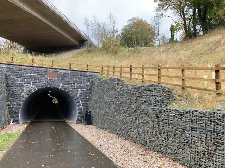 New tunnel portal showing gabion wall and masonry arch on a fully accessible trail created by re-purposing the old Keswick to Threlkeld railway.