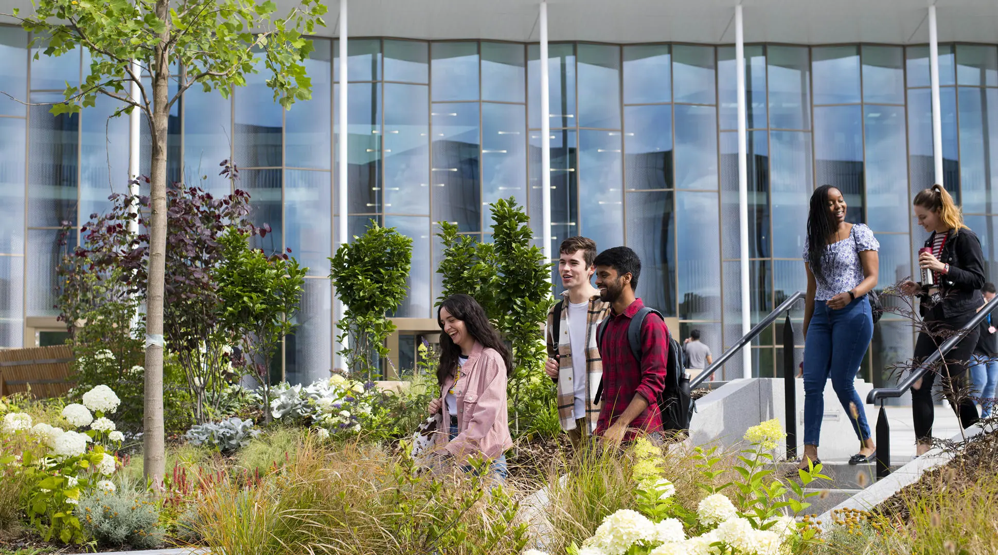 group of students walking amongst plants outside the student centre in preston