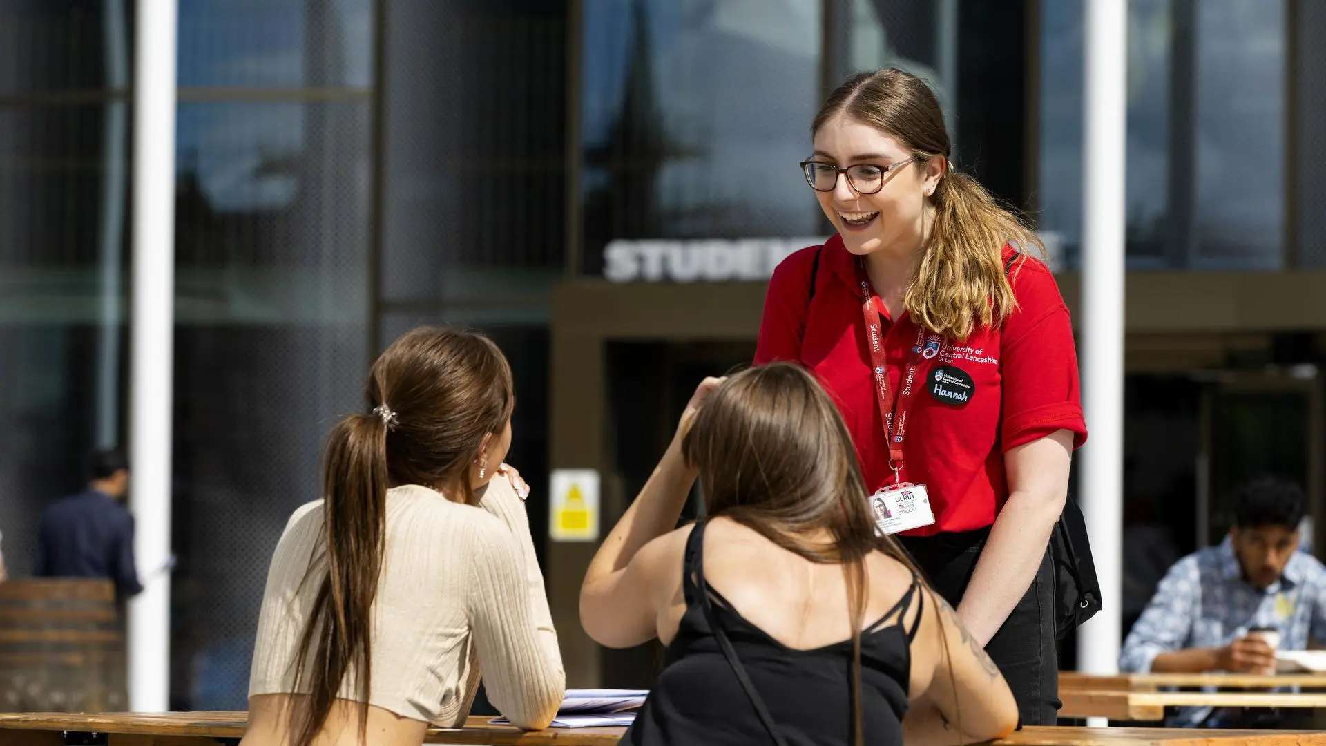 A student ambassador talks to two visitors at Preston Campus.