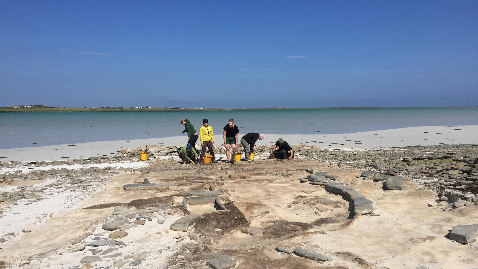 Researchers conducting an archaeology dig on a beach