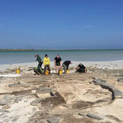 Researchers conducting an archaeology dig on a beach
