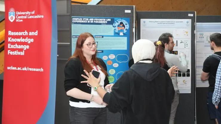 A student talking about her work at the Postgraduate Research Poster event.