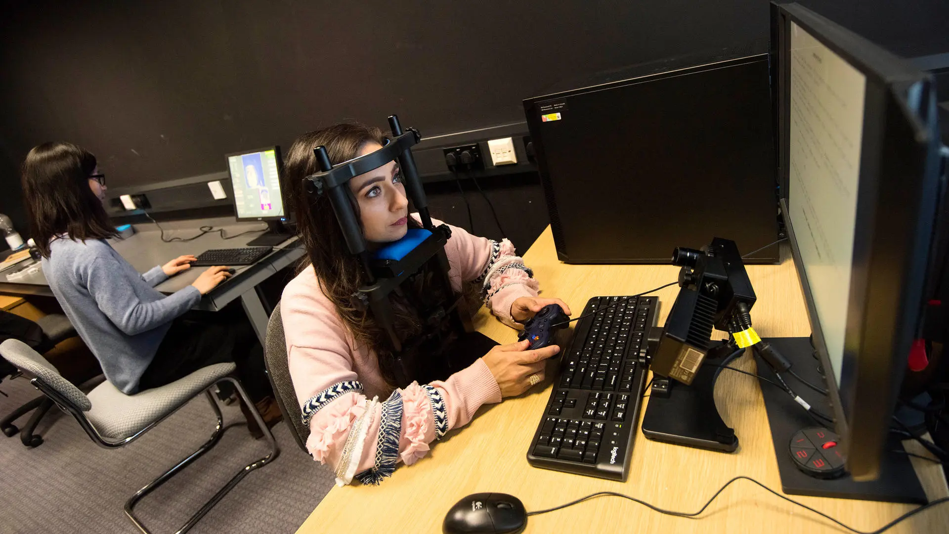 Psychology researcher wearing test equipment while working at a computer