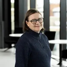 Nathalie smiling in glasses and a jumper