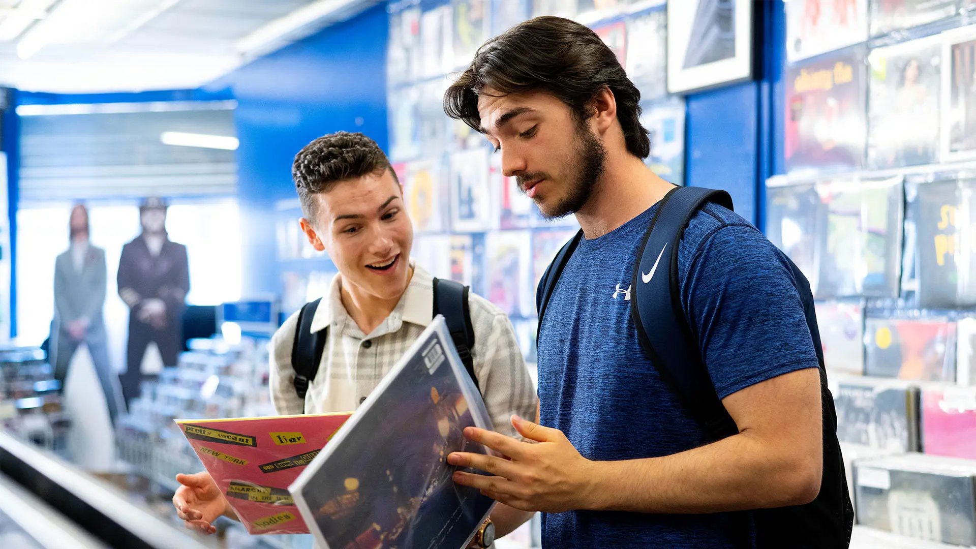 Two students showing each other vinyl's in record store in Preston city centre