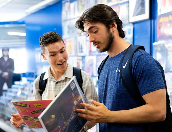 Two students showing each other vinyl's in record store in Preston city centre