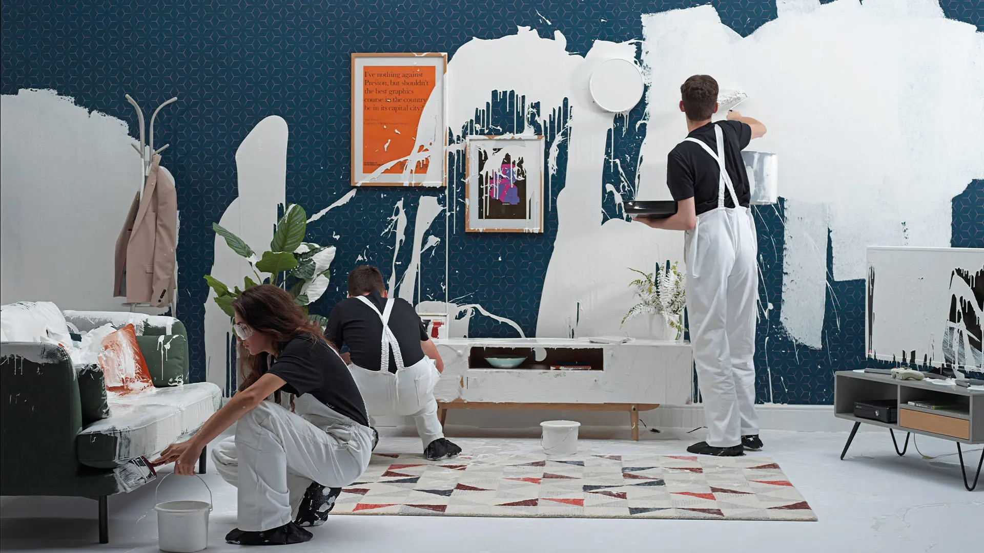 Students in overall painting over room with white paint