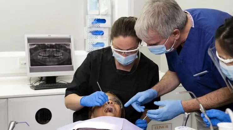Student examining a patients teeth