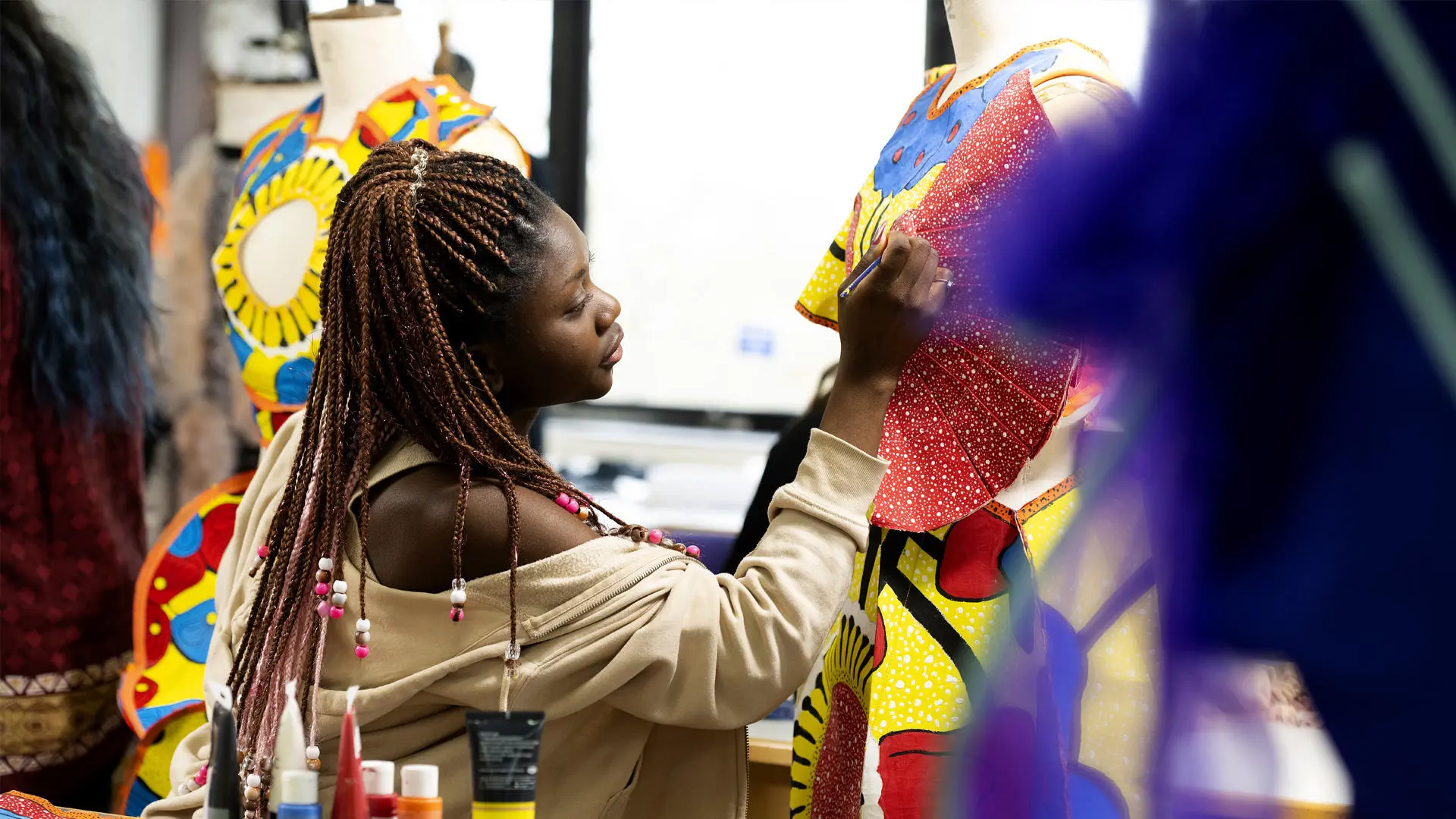 fashion student working on clothing on a mannequin in the fashion studio
