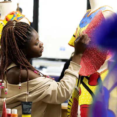 fashion student working on clothing on a mannequin in the fashion studio