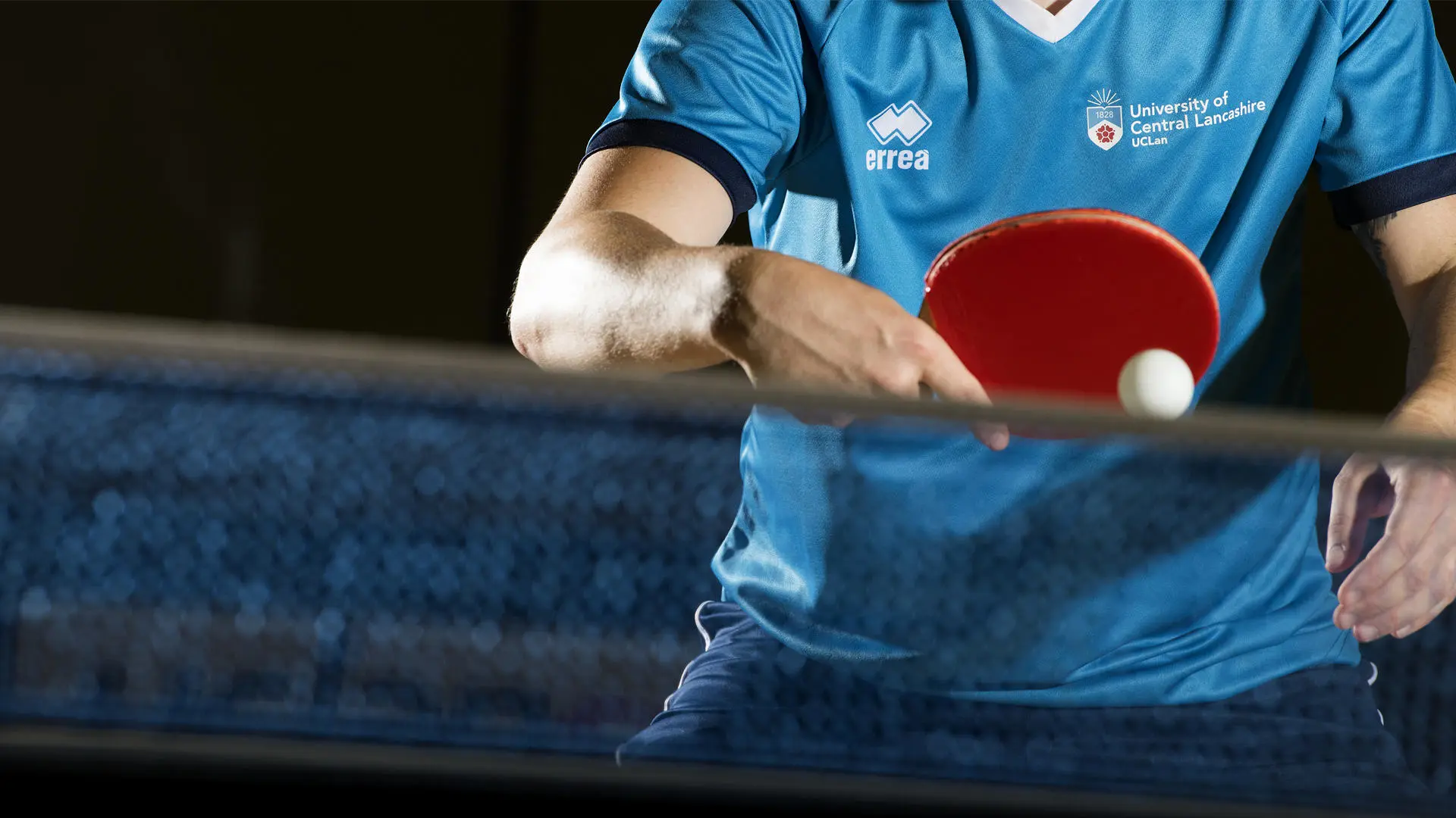 person hitting a table tennis ball against a net