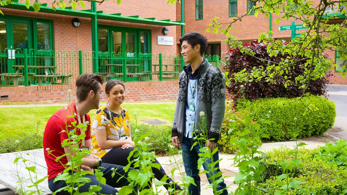 Students chatting in leafy campus