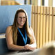 student coach danielle hunt sat in the student centre at a table and smiling