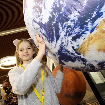 child holding model of the world at lancashire science festival in preston