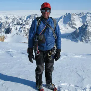Profile picture of Simon Yates, standing atop a snowy mountain