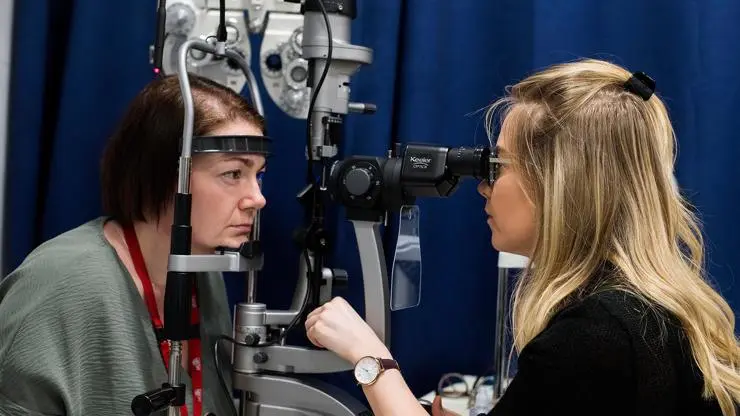 Students using Optometry equipment.