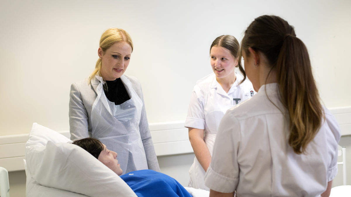 three students in a patient treatment scenario with a dummy