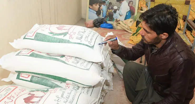 Carefully labelling bags of flour ready for distribution to participating households.