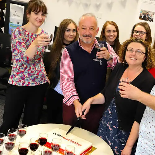 David Roche, Chair of the London Book Fair and of New Writing North, cutting the celebratory cake with Debbie Williams, Head of UCLan Publishing, surrounded by publishing students and staff.
