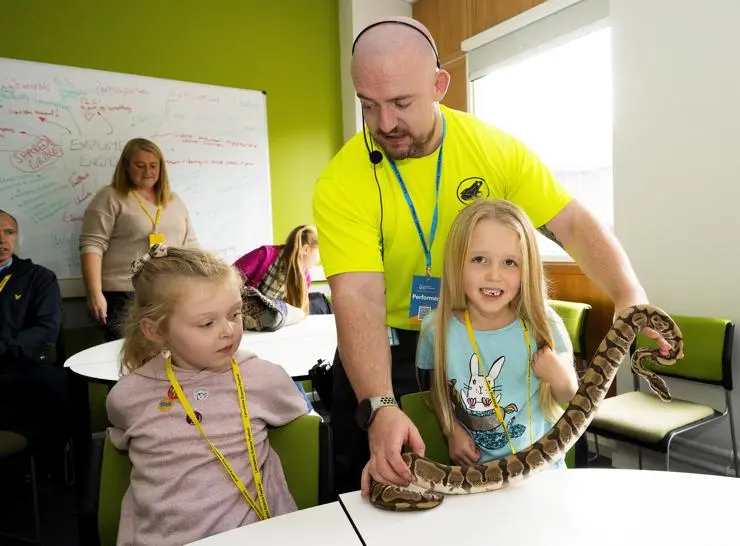 Five-year-olds Alice Parker and Pippa Miller, from Preston, looking at a snake held by Zoolab’s Rob Hunt