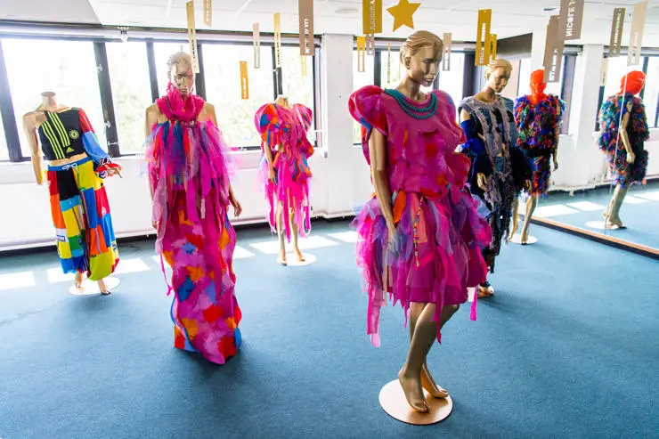 Six mannequins displaying bright dresses